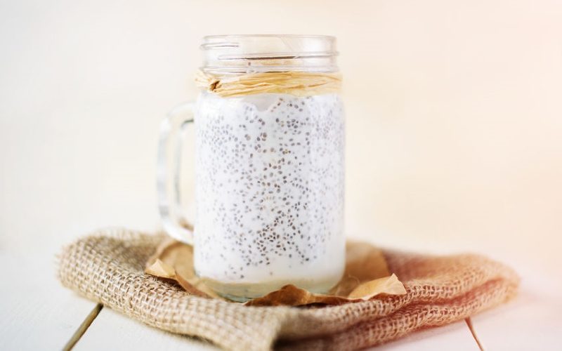 Chia seed pudding in a jar on white wooden background